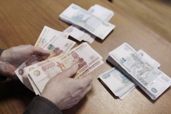 An employee of a local company, producing equipment for electrical meters, counts Russian rouble banknotes in Stavropol